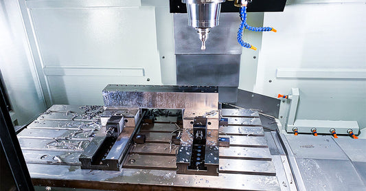 Ark CNC İstanbul tesisinde modern CNC dik işlem merkezinde (CNC freze) soğutma sıvısı ile kompleks geometriye sahip metal kalıp bloğu işleme operasyonu detayı.